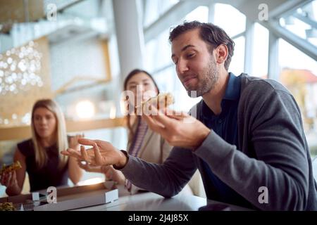 Young business people eating during a lunch break in a pleasant atmosphere in the company building. Business, people, company Stock Photo