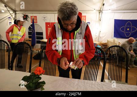 Medyka, Poland. 15th Apr, 2022. Pictured here lighting Yahrzeit candles ''” an apt symbol of mourning with so many Ukrainians dying in Russia's war, and the Jews of the past who were similarly executed, from Pharaoh to Hitler, is Tod Elan, a Jewish business man from the USA/Israel, who had his Russian assets frozen at the start of the war. He responded by coming to the Medyka border camp and volunteering to help the Ukrainians. Tod is helping prepare the Passover Seder table, where an international group of Jews from Israel and Ukraine, along with Chinese, Scottish, Polish and others, celebr Stock Photo