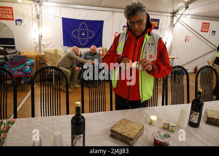 Medyka, Poland. 15th Apr, 2022. Pictured here lighting Yahrzeit candles ''” an apt symbol of mourning with so many Ukrainians dying in Russia's war, and the Jews of the past who were similarly executed, from Pharaoh to Hitler, is Tod Elan, a Jewish business man from the USA/Israel, who had his Russian assets frozen at the start of the war. He responded by coming to the Medyka border camp and volunteering to help the Ukrainians. Tod is helping prepare the Passover Seder table, where an international group of Jews from Israel and Ukraine, along with Chinese, Scottish, Polish and others, celebr Stock Photo