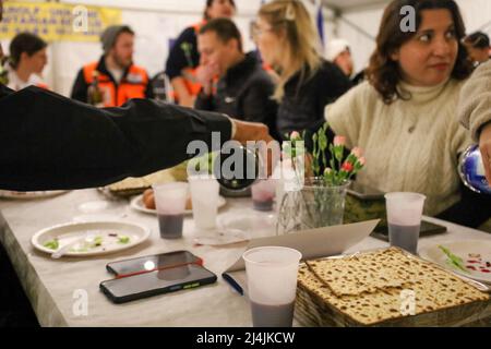 Medyka, Poland. 15th Apr, 2022. An international group of Jews from Israel and Ukraine, along with Chinese, Scottish, Polish and others, celebrate a very special Passover at the Medyka Ukrainian Refugee Border Camp, an emergent humanitarian hub on the Polish side of the border between Poland and Ukraine, not far from Lviv. It was hosted by the Chinese volunteers in the 'New Federal State of China'' tent, and run by the Lev Echad, ('One Heart'' in English) staff and volunteers from Israel and elsewhere. Passover is a holiday celebrating the passing over from slavery and oppression into fr Stock Photo