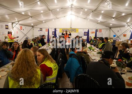 Medyka, Poland. 15th Apr, 2022. An international group of Jewish volunteers from Israel and Ukraine, along with Chinese, Scottish, Polish and others, celebrate a very special Passover at the Medyka Ukrainian Refugee Border Camp, an emergent humanitarian hub on the Polish side of the border between Poland and Ukraine, not far from Lviv. It was hosted by the Chinese volunteers in the 'New Federal State of China'' tent, and run by the Lev Echad, ('One Heart'' in English) staff and volunteers from Israel and elsewhere. Passover is a holiday celebrating the passing over from slavery and oppre Stock Photo