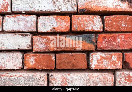 Brick wall with weathered paint, close-up texture background Stock Photo