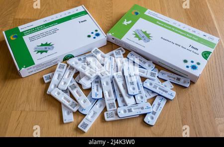 Covid-19 or coronavirus rapid antigen self-testing packs or kits and a pile of negative lateral flow test sticks during the pandemic Stock Photo