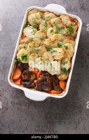 Homemade Lancashire hotpot a stew consists of lamb, onion, carrot, Worcestershire sauce, topped with sliced potatoes closeup in the baking dish on the Stock Photo