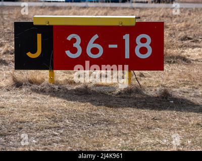 Helsinki / Finland - APRIL 16, 2022: Closeup of runway hold position sign at taxiway J. Stock Photo