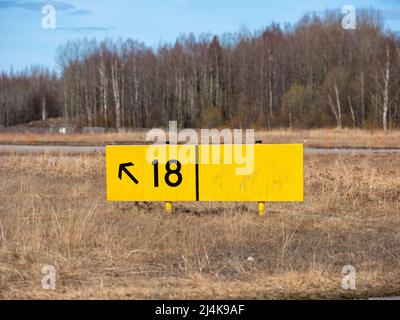 Helsinki / Finland - APRIL 16, 2022: Closeup of an yellow airport taziway direction sign. Stock Photo