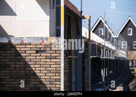 Construction site with houses under construction. In the foreground, the cavity wall insulation is visible between the brick outer and inner wall Stock Photo