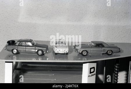 1970s, historical, three metal toy cars on the roof of a multi-storey toy garage or car park, England, UK. Stock Photo