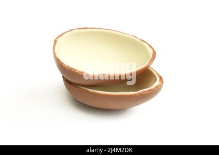Two halves of milk chocolate egg isolated on white background. Stock Photo