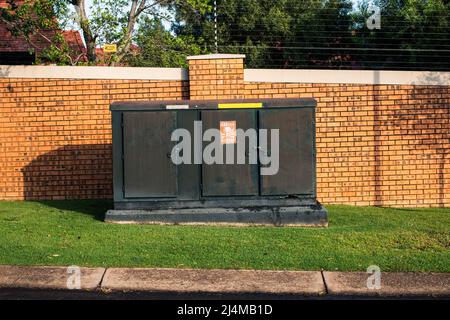 Green transformer box, with a danger sign on a sunny day Stock Photo