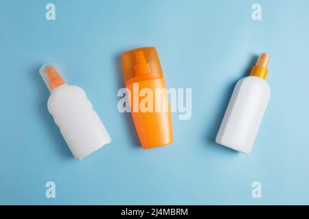 Sun cream, sun hat, cream, towel, sunscreen bottle, sun cream, lotion bottle, sunglasses seashells on a blue background. Sun protection. Beach flat la Stock Photo