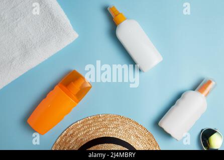beach bag with beach accessories on a colored background top view. Sunscreen, towel, glasses, hat. Stock Photo