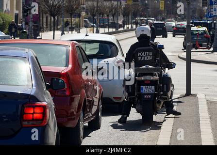 Bucharest, Romania - April 06, 2022: A policeman sitting on BMW R 1200 RT authority motorcycles, waiting at red traffic lights, in Bucharest. This ima Stock Photo