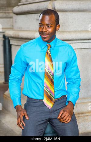 Dressing in a light blue shirt, a colorful pattern tie, gray pants, wearing  glasses, a young black college student is standing by a pattern wall on ca  Stock Photo - Alamy