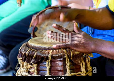 Musician playing a rudimentary percursion instrument called atabaque during afro-brazilian capoeira cultural manifestation Stock Photo