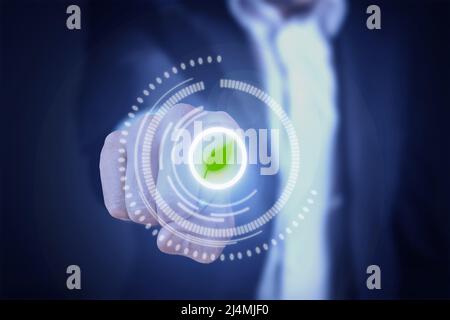 Man in suit, finger presses virtual green leaf button. Green technology concept Stock Photo