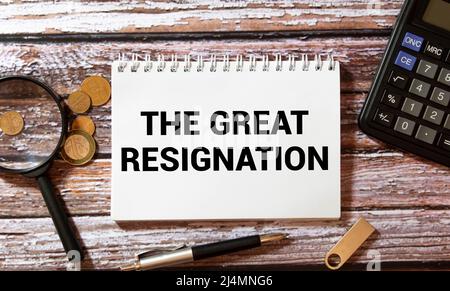 Red pencil, notebook on black copy space background with handwritten text THE GREAT RESIGNATION, concept of the BIG QUIT, million employees voluntaril Stock Photo