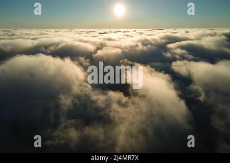 Aerial view at high altitude of dense puffy cumulus clouds forming before rainstorm in evening. Stock Photo