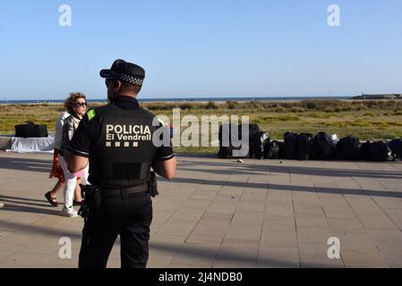 Vendrell, Spain. 16th Apr, 2022. A local police agent observes the products collected in bags from illegal street vendors on Paseo Maritimo Street. The Vendrell local police fights daily against the illegal street vendors and forces them to collect their products on the street, which are mostly counterfeit clothing, bags and sports shoes from commercial brands such as Nike, Adidas, Louis Vuitton, Tous. Citizens who buy those products are at risk of being fined for the crime of buying illegal products. Credit: SOPA Images Limited/Alamy Live News Stock Photo