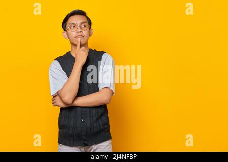 Portrait of young Asian man thinking about question with finger hand on chin Stock Photo