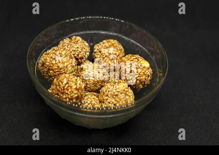 The sweet sesame balls are in a cup. On a black background Stock Photo