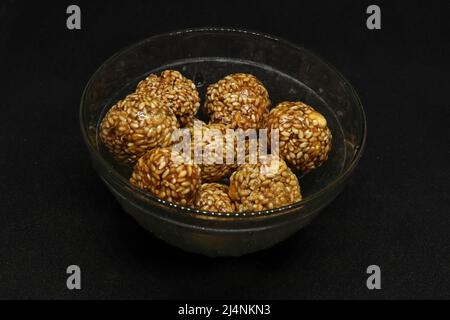 The sweet sesame balls are in a cup. On a black background Stock Photo