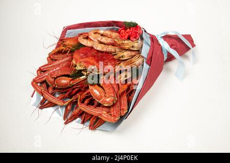 Bouquet consisting of boiled crayfish, shrimps and a large crab on a white background Stock Photo