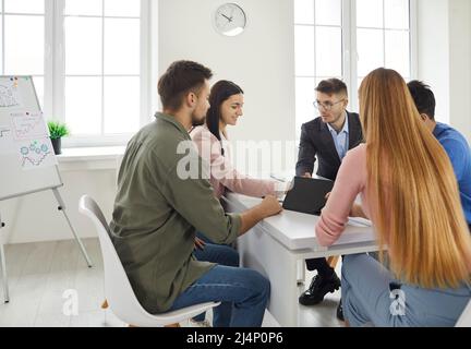 Team work and team building is a success. Busy start up partners working in casual clothes, so focused, discussing the ideas for new strategy of Stock Photo