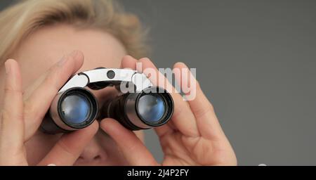 looking through binoculars on grey black background with people stock image stock photo Stock Photo