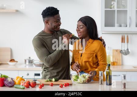 Romantic Black Spouses Having Fun While Preparing Food In Cozy Kitchen Stock Photo