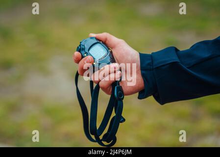 Stopwatch in the hands of a running coach. Close-up, illustration photo from sports running training Stock Photo