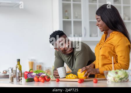 Portrait Of Young Happy Black Couple Relaxing In Kitchen Interior Stock Photo