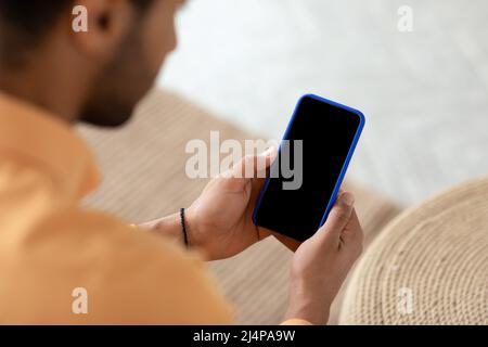 Young guy using cell with empty screen, mockup Stock Photo
