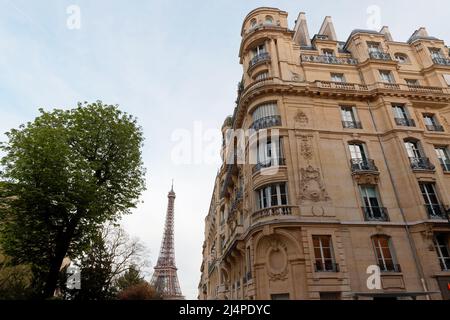 The facade of traditional French house with typical balconies and windows with Eiffel tower in the background . Paris. Stock Photo