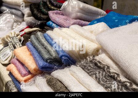 Stack of knitted wool Orenburg scarves. Crochet, pattern. Stock Photo