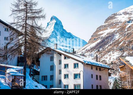 View of snow covered town and Matterhorn mountain against sky during winter Stock Photo