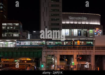 Yodobashi Camera store in Akihabara with a Keihin-Tohoku Line train arriving at the station Tokyo, Japan. Stock Photo