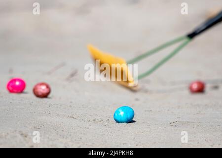 Norderney, Germany. 17th Apr, 2022. Colorful Easter eggs lie in the sand on Easter Sunday during the traditional "Eiertrullern" on the island's western beach. In this East Frisian custom, hard-boiled Easter eggs are rolled from a hill in a race. Credit: Hauke-Christian Dittrich/dpa/17�Թ����� Live News Stock Photo