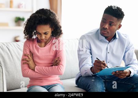 Angry african american girl having conversation with child psychologist Stock Photo
