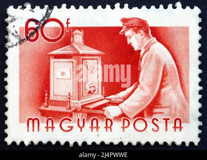 HUNGARY - CIRCA 1955: a stamp printed in the Hungary shows Postman Emptying Mail Box, circa 1955 Stock Photo