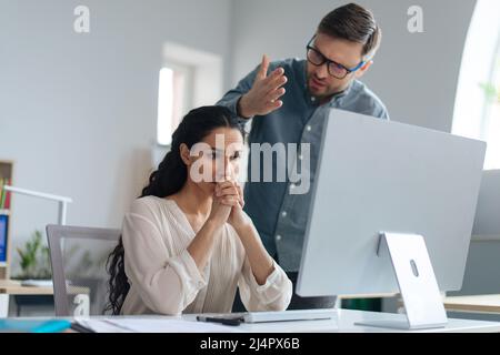 Angry boss scolding female employee for making error in business project at office. Workplace stress concept Stock Photo