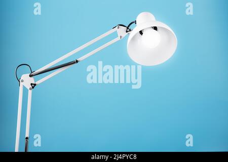 Office table lamp on blue background with space for text and idea concept Stock Photo