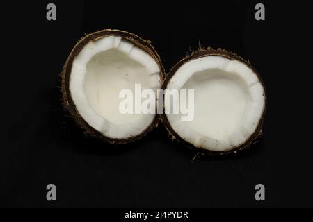 coconut cut into two pieces. on a black background Stock Photo