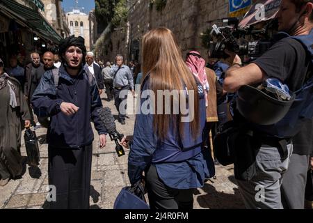 TV news crew wearing protective flak jacket marked 'press' interviews a Palestinian man in Al Wad street which Israelis call Haggai in the Muslim Quarter, old city of Jerusalem Israel Stock Photo