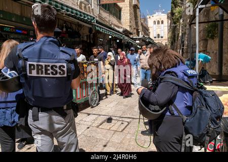 TV news crew wearing protective flak jacket marked 'press' filming in Al Wad street which Israelis call Haggai in the Muslim Quarter, old city of Jerusalem Israel Stock Photo