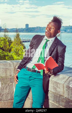 Urban Fashion. Dressing in a black blazer, green necktie, white undershirt, green  pants, a young black guy with mohawk hair is standing by a river, r Stock  Photo - Alamy