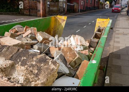 Skip Building Rubble A builders skip containing rubble and bricks from a ongoing home ...