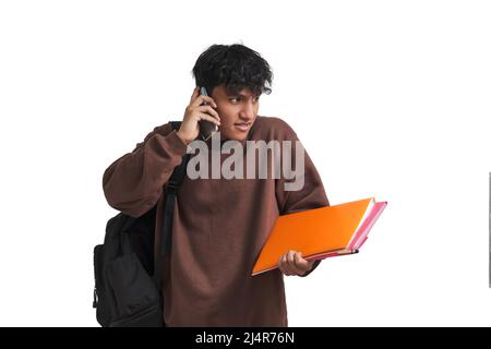 Young peruvian student talking on the smartphone and shrugging, isolated. Stock Photo