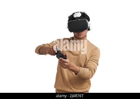 Young peruvian man playing games with joystick and vr headset, isolated. Stock Photo