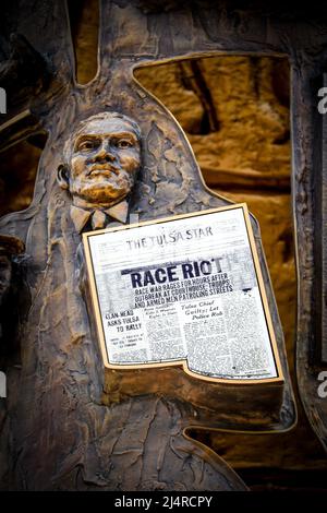 07 2- 2021 Tulsa USA Man holds newspaper - Tulsa Star with headlines Race Riot - part of mural sculpture at Reconcilionation Park in Tulsa Oklahoma. Stock Photo